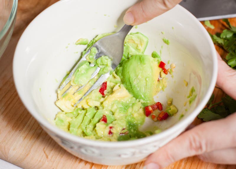 Voorbereiding van avocado en garnalensalsa stock foto