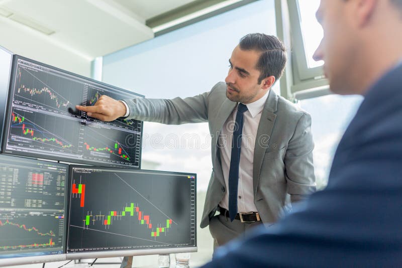 Voorraadmakelaars die computerschermen bekijken, die online de handel drijven stock afbeeldingen Voorraadmakelaars die computerschermen bekijken, die online de handel drijven stock afbeeldingen