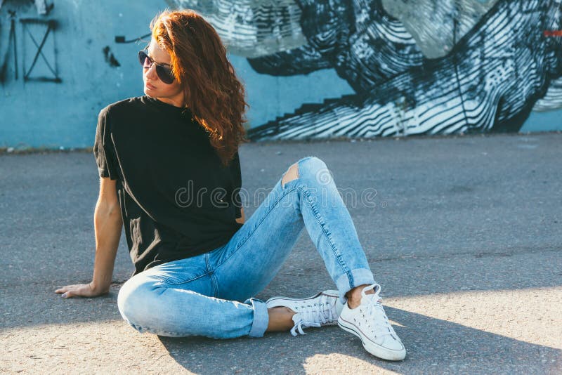 Vorbildliches tragendes einfaches T-Shirt und Sonnenbrille, die über der Straße wal aufwirft stockfoto