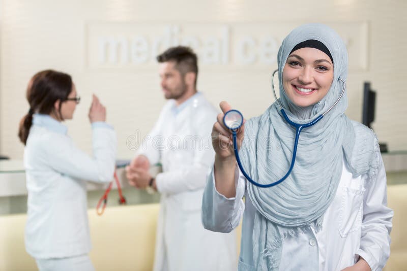 Vorderansicht einer arabischen Doktorfrau, die Stethoskop zeigt