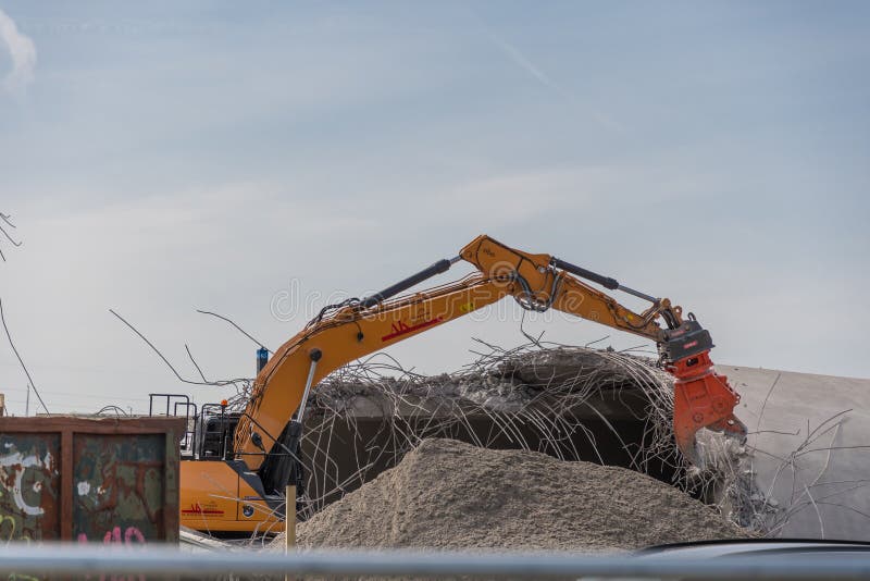 Vordingborg Denmark - April 7. 2018: excavator ripping concrete building apart