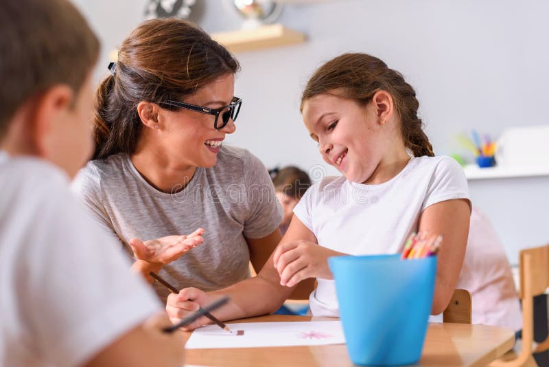 Vorschullehrer, der intelligentes Kind auf Kindergarten betrachtet lizenzfreie stockfotos Vorschullehrer, der intelligentes Kind auf Kindergarten betrachtet lizenzfreie stockfotos