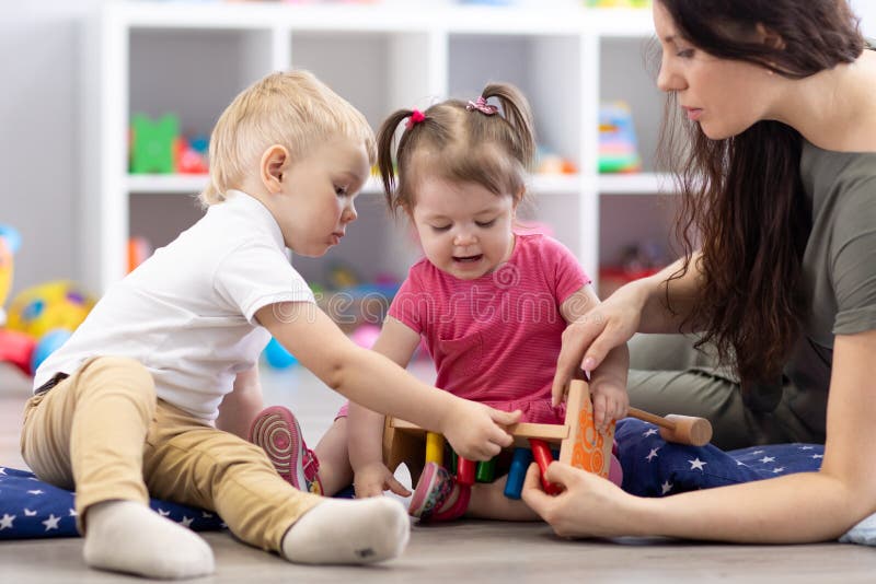Vorschülerkinder, die mit Bildung Holz Spielzeug im Kindergarten oder Tagesstätte spielen Kleinkinder mit Lehrer in