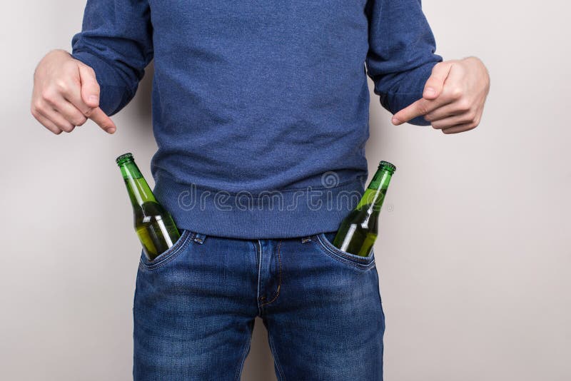 Vous l'aimez concept Photo en gros plan cultivée du type macho plein d'assurance payant l'attantion sur ses deux bouteilles dans image stock Vous l'aimez concept Photo en gros plan cultivée du type macho plein d'assurance payant l'attantion sur ses deux bouteilles dans image stock