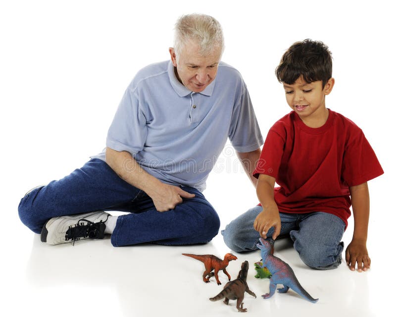 An adorable preschooler showing his grandpa his collection of toy dinosaurs. On a white background. An adorable preschooler showing his grandpa his collection of toy dinosaurs. On a white background.