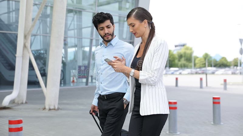 Voyage de travail Hommes d'affaires utilisant le téléphone marchant à l'aéroport banque de vidéos