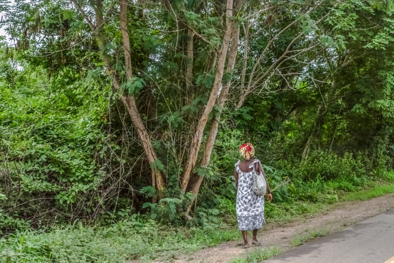 Voyage par Angola& x27 ; terres 2018 de s : Vue de femme de nouveau à côté de la route pour marcher le fond images libres de droits Voyage par Angola& x27 ; terres 2018 de s : Vue de femme de nouveau à côté de la route pour marcher le fond images libres de droits