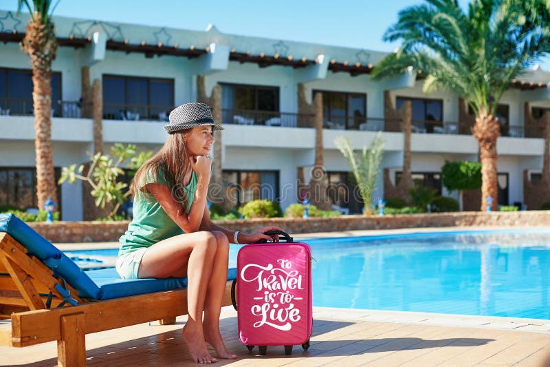 Voyage, vacances d'été et concept de vacances - belle femme marchant près de l'espace piscine d'hôtel avec la valise rouge en Egy image stock