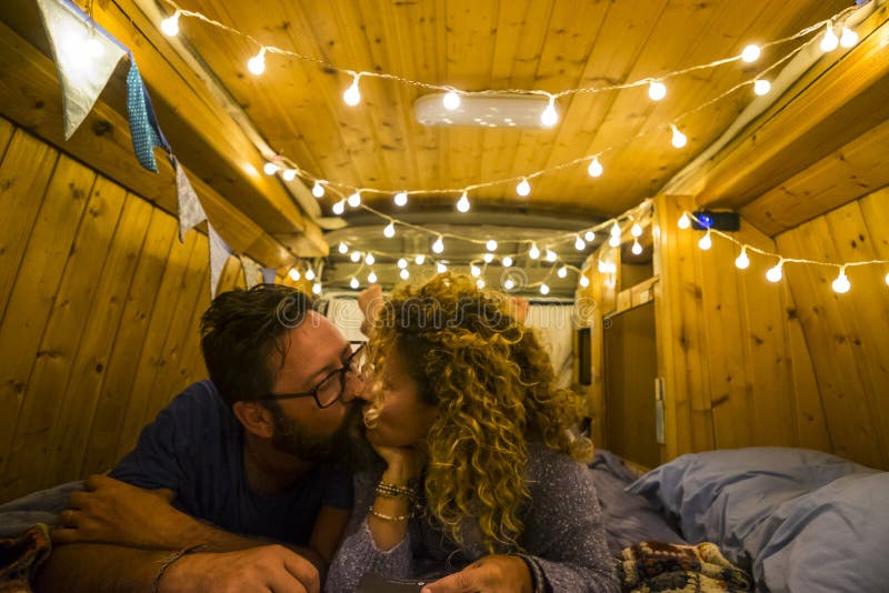 Voyager et nuit romantique à l'intérieur d'un fourgon en bois restauré magnifique pour un couple de caucasiens adultes heureux en photographie stock Voyager et nuit romantique à l'intérieur d'un fourgon en bois restauré magnifique pour un couple de caucasiens adultes heureux en photographie stock