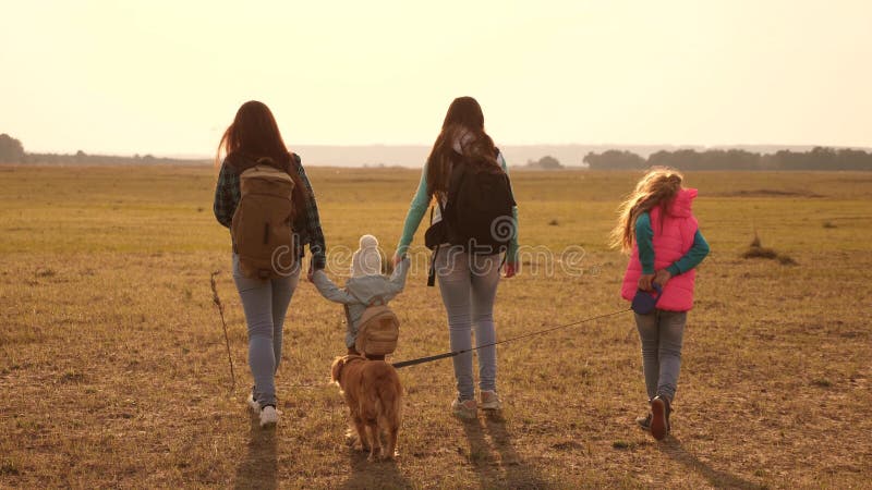 Voyages de famille avec le chien? travers les plaines et les montagnes m? re, filles et touristes? la maison d'animaux familiers photos stock