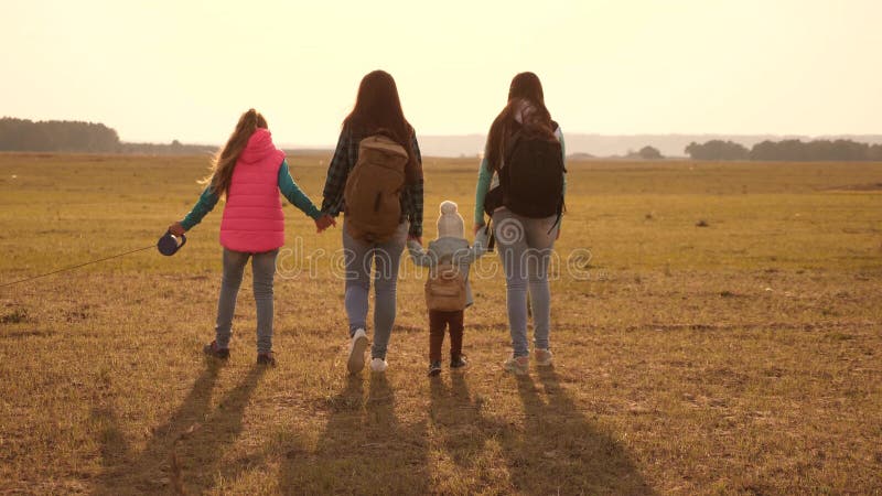 Voyages de famille avec le chien? travers les plaines et les montagnes m? re, filles et touristes? la maison d'animaux familiers image stock
