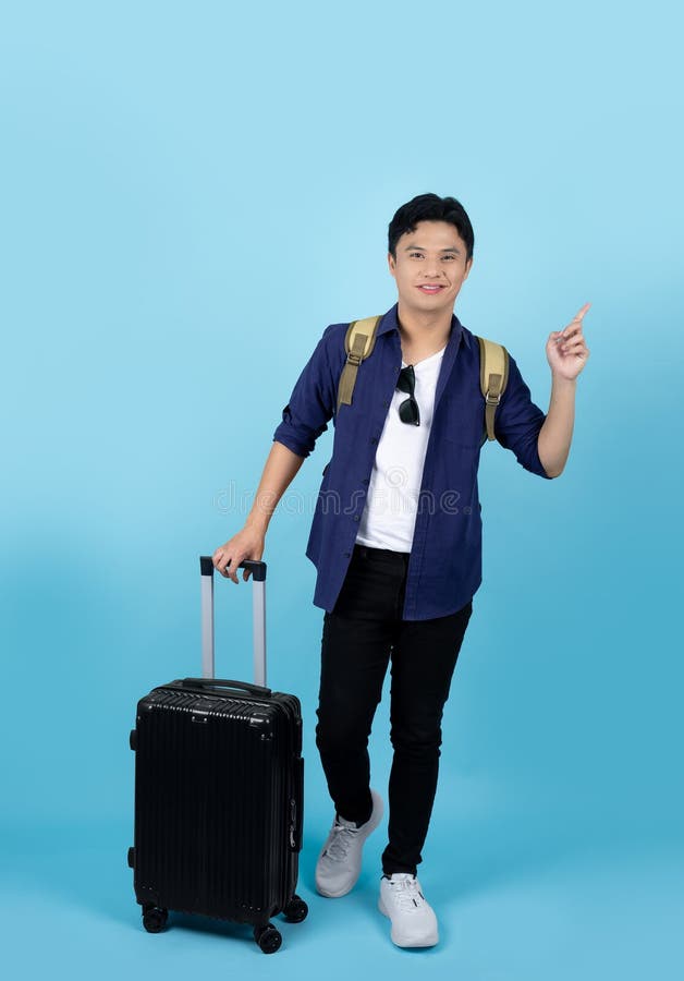 Voyageur de corps entier homme d'origine asiatique portant des vêtements décontractés tenir valise valise valise isolée sur fond b photo libre de droits