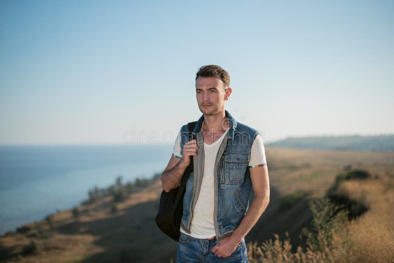 Voyageur de jeune homme avec la détente de sac à dos extérieure Vacances et hausse d'été image libre de droits Voyageur de jeune homme avec la détente de sac à dos extérieure Vacances et hausse d'été image libre de droits