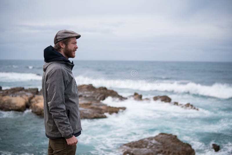 Voyageur sur les roches près de la mer regardant loin l'horizon Rocky Atlantic Ocean Coastline et temps orageux image libre de droits Voyageur sur les roches près de la mer regardant loin l'horizon Rocky Atlantic Ocean Coastline et temps orageux image libre de droits