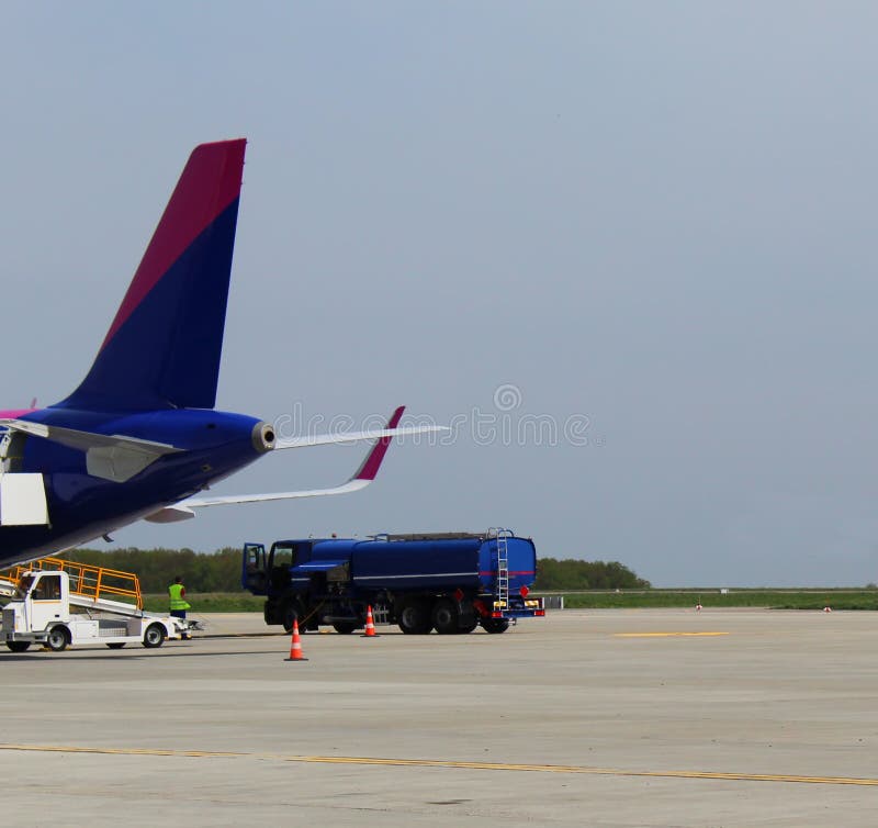 Vrachtwagen die een vliegtuig op de luchthaven bijtanken stock fotografie Vrachtwagen die een vliegtuig op de luchthaven bijtanken stock fotografie