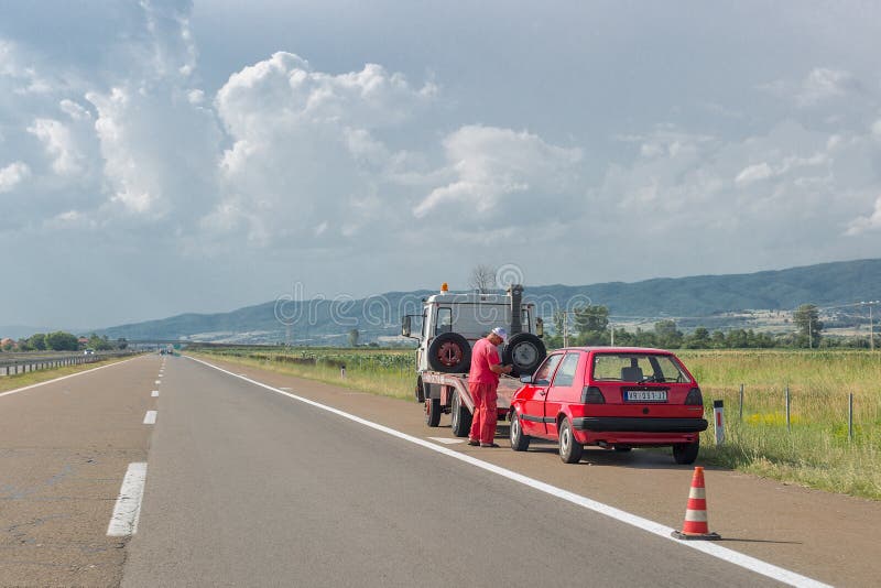 Vranje, Serbia 23 giugno 2019: L'addetto al servizio di rimorchio caricerà la vecchia auto danneggiata su un carro attrezzi sull' fotografia stock Vranje, Serbia 23 giugno 2019: L'addetto al servizio di rimorchio caricerà la vecchia auto danneggiata su un carro attrezzi sull' fotografia stock