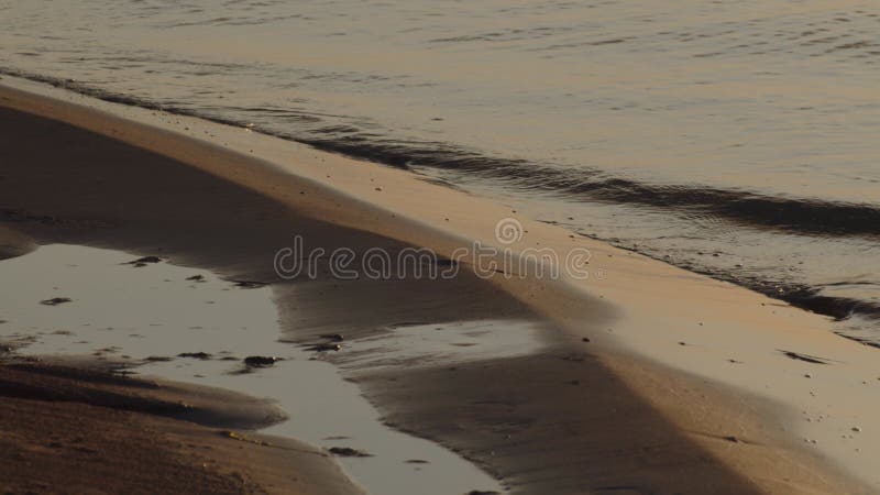 Vreedzame golven op een zonsondergang.