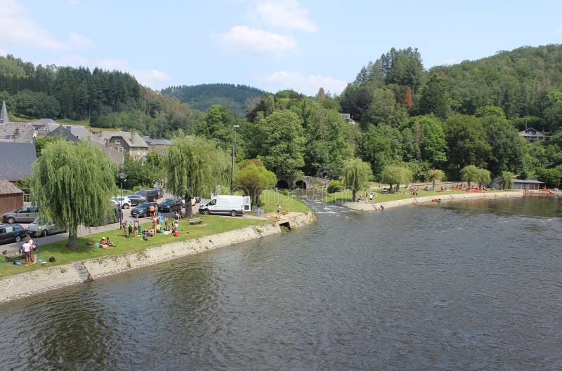 VRESSE-SUR-SEMOIS, BELGIUM, 22 JULY 2021: People enjoying a warm summers day on the banks of the Semois River in the Belgian Ardennes. Picturesque town of Vresse-sur-Semois is a popular vacation destination in Wallonia. VRESSE-SUR-SEMOIS, BELGIUM, 22 JULY 2021: People enjoying a warm summers day on the banks of the Semois River in the Belgian Ardennes. Picturesque town of Vresse-sur-Semois is a popular vacation destination in Wallonia