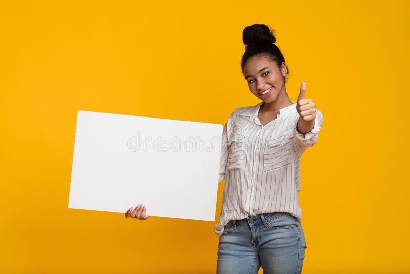 My Recommendation. Black Girl Holding Blank Placard With Free Space For Your Ad And Showing Thumb Up, Recommending Something, Yellow Background. My Recommendation. Black Girl Holding Blank Placard With Free Space For Your Ad And Showing Thumb Up, Recommending Something, Yellow Background