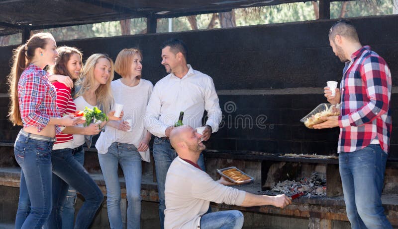 Vrienden die bij grillpartij ontspannen stock foto's Vrienden die bij grillpartij ontspannen stock foto's