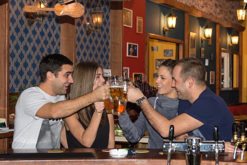Vrienden die dranken in een bar hebben stock afbeeldingen Vrienden die dranken in een bar hebben stock afbeeldingen