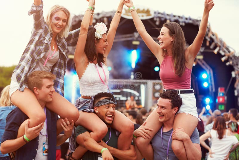 Vrienden die pret in de menigte hebben bij een muziekfestival