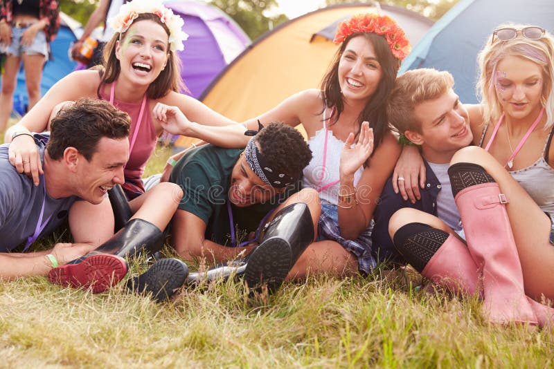 Vrienden die pret op het kampeerterrein hebben bij een muziekfestival
