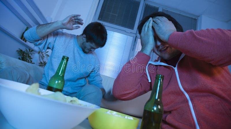 Vrienden die Sport op Gelijke op TV letten stock afbeelding Vrienden die Sport op Gelijke op TV letten stock afbeelding