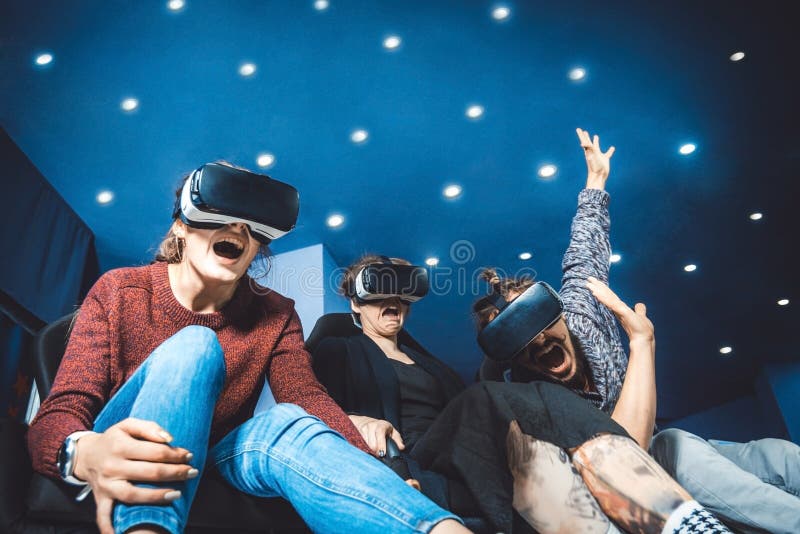 Vrienden die in virtuele glazen op films in de bioskoop met SP letten royalty-vrije stock afbeeldingen Vrienden die in virtuele glazen op films in de bioskoop met SP letten royalty-vrije stock afbeeldingen