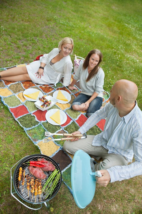 Vrienden die Voedsel eten bij een Openluchtpicknick royalty-vrije stock foto Vrienden die Voedsel eten bij een Openluchtpicknick royalty-vrije stock foto