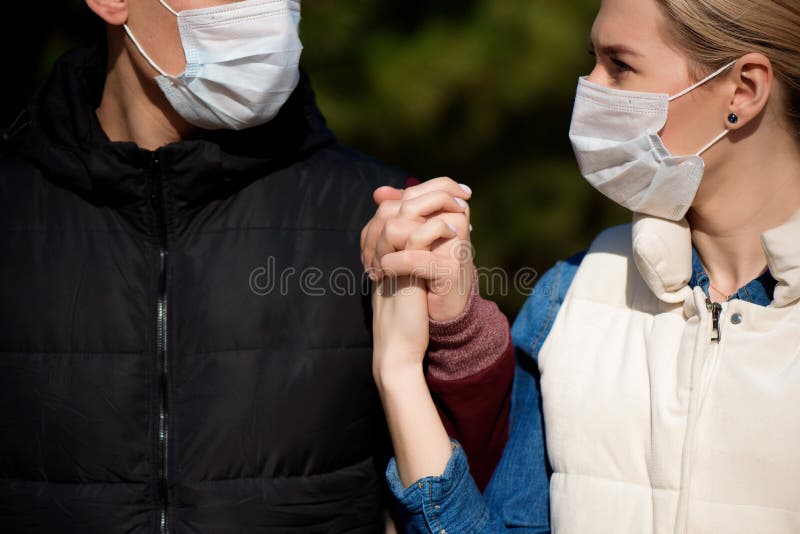 Vrienden in hun gezicht lopen in het park uit angst besmet te raken met het coronavirus