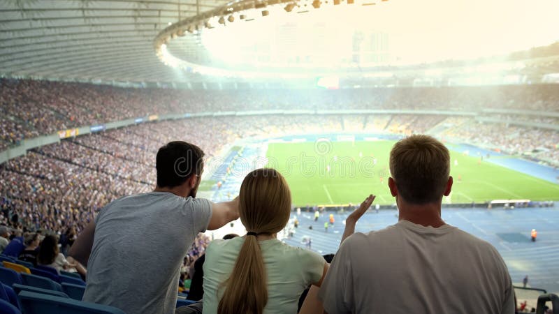 Vrienden verontwaardigd bij scheidsrechtersbesluit in voetbalwedstrijd bij stadion, oneerlijk spel stock afbeeldingen Vrienden verontwaardigd bij scheidsrechtersbesluit in voetbalwedstrijd bij stadion, oneerlijk spel stock afbeeldingen