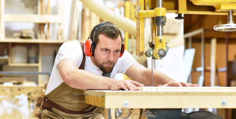Vriendschappelijke timmerman met van de oorbeschermers en werkkledij worki stock afbeelding Vriendschappelijke timmerman met van de oorbeschermers en werkkledij worki stock afbeelding
