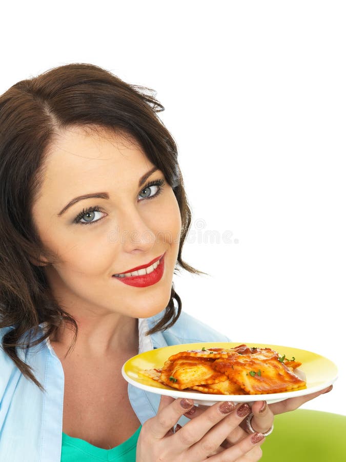 An Attractive beautiful young hispanic or european woman, holding up a plate of delicious tomato ravioli, a smaller portion size as part as a calorie controlled diet or meal plan, shot against a white background looking into the camera smiling. An Attractive beautiful young hispanic or european woman, holding up a plate of delicious tomato ravioli, a smaller portion size as part as a calorie controlled diet or meal plan, shot against a white background looking into the camera smiling.