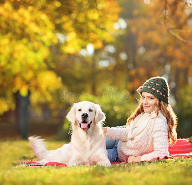 Vrij het vrouwelijke liggen met haar labrador retriever-hond in een pa royalty-vrije stock foto's Vrij het vrouwelijke liggen met haar labrador retriever-hond in een pa royalty-vrije stock foto's