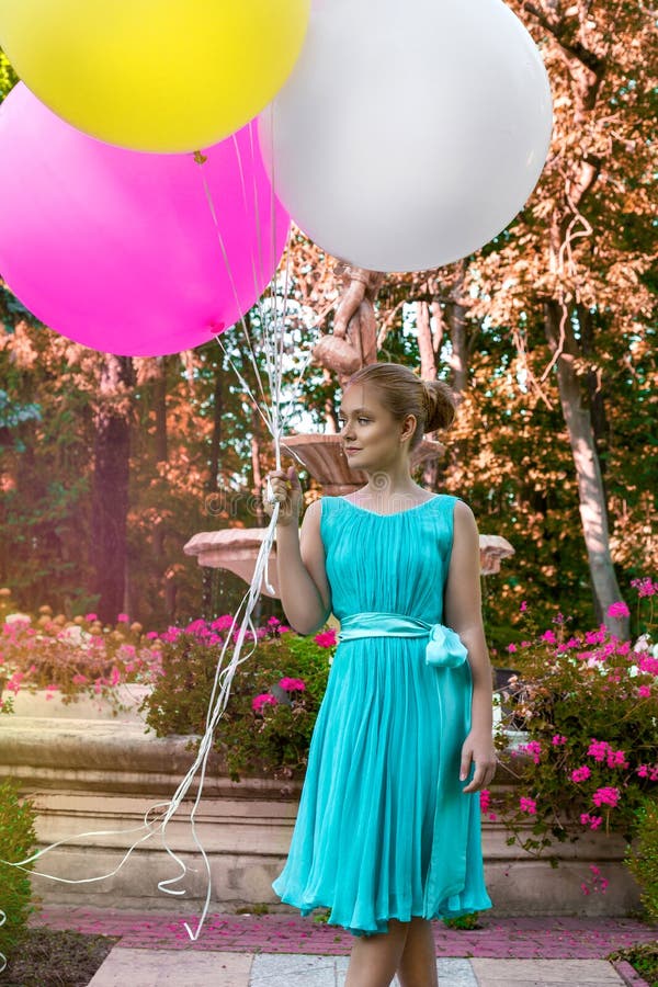 Vrij jong meisje die met grote kleurrijke ballons in het park dichtbij de stad lopen - beeld stock afbeelding Vrij jong meisje die met grote kleurrijke ballons in het park dichtbij de stad lopen - beeld stock afbeelding