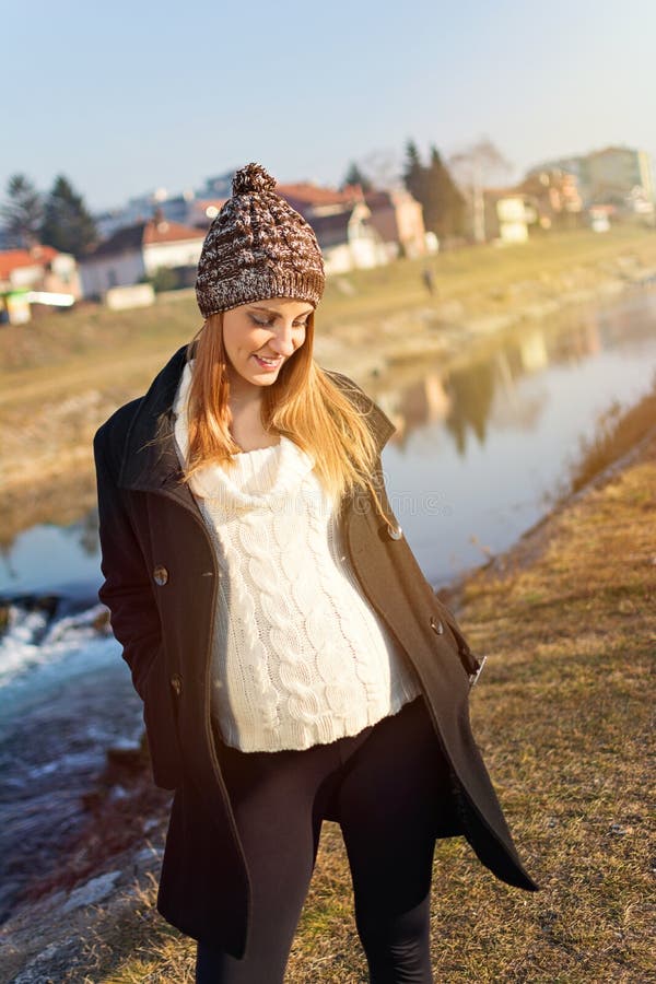 Vrij jonge zwangere vrouw die zich door de rivier bevinden stock afbeeldingen Vrij jonge zwangere vrouw die zich door de rivier bevinden stock afbeeldingen