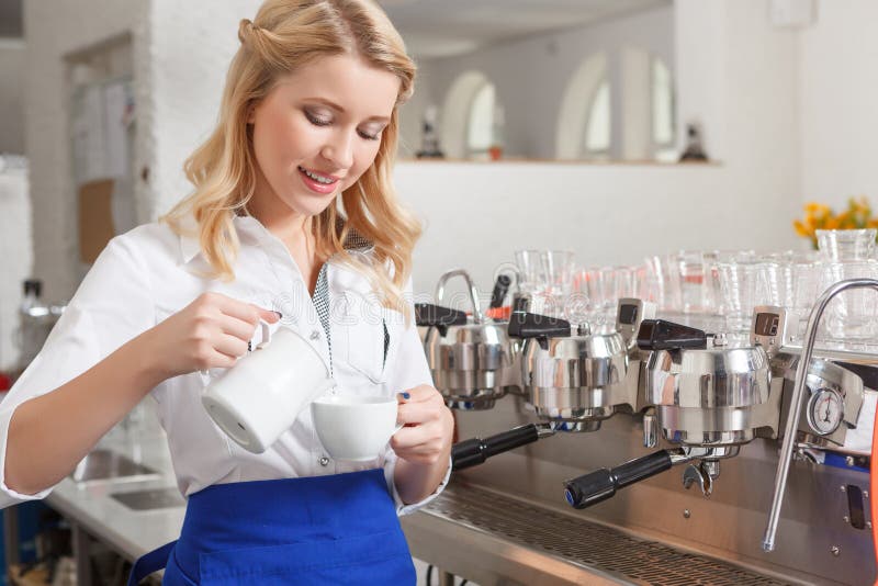 Vrij vrouwelijke barista die wat melk in kop gieten stock afbeelding Vrij vrouwelijke barista die wat melk in kop gieten stock afbeelding
