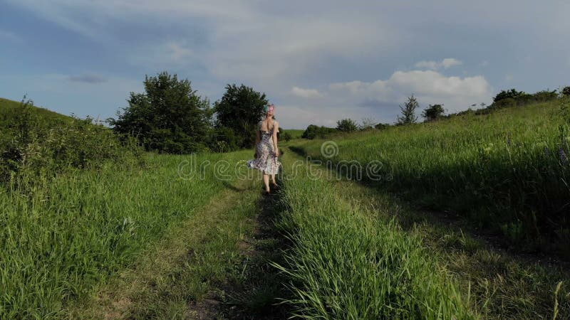 Vrolijk jong meisje die blootvoets op een landweg lopen Genomen op Mavik-Lucht 4k 100kbps