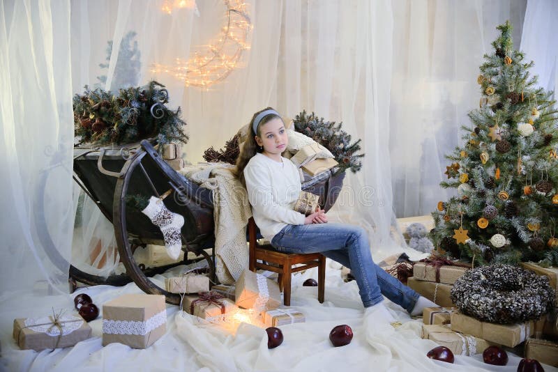 Vrolijk kerstfeest en vrolijke feestdagen! Cute dreamy girl op de achtergrond van kerstversieringen pastelkleuren stock afbeelding Vrolijk kerstfeest en vrolijke feestdagen! Cute dreamy girl op de achtergrond van kerstversieringen pastelkleuren stock afbeelding