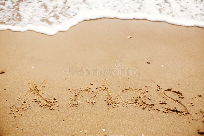 Vrolijk Kerstmisconcept, gelukkige vakantie Kerstmistekst op zandig strand royalty-vrije stock foto's Vrolijk Kerstmisconcept, gelukkige vakantie Kerstmistekst op zandig strand royalty-vrije stock foto's