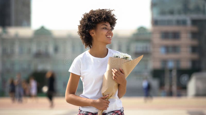 Vrolijk meisje die met boeket van bloemen, heden van vriend, geluk glimlachen royalty-vrije stock foto's Vrolijk meisje die met boeket van bloemen, heden van vriend, geluk glimlachen royalty-vrije stock foto's