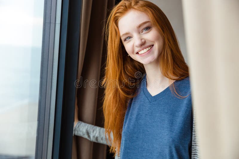 Vrolijk mooi meisje die met rood haar camera en het glimlachen kijken royalty-vrije stock foto Vrolijk mooi meisje die met rood haar camera en het glimlachen kijken royalty-vrije stock foto