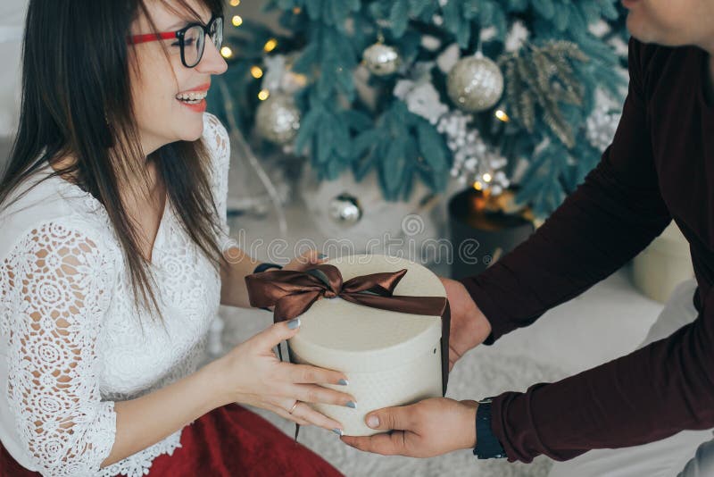 Vrolijk paar die met gift in handen samen van op Kerstmisvooravond genieten royalty-vrije stock afbeeldingen Vrolijk paar die met gift in handen samen van op Kerstmisvooravond genieten royalty-vrije stock afbeeldingen