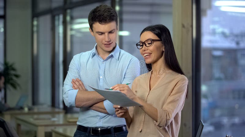Vrolijke creatieve ontwerpers die orde, Aziatische vrouw bespreken die nota'sdocument maken stock afbeelding Vrolijke creatieve ontwerpers die orde, Aziatische vrouw bespreken die nota'sdocument maken stock afbeelding