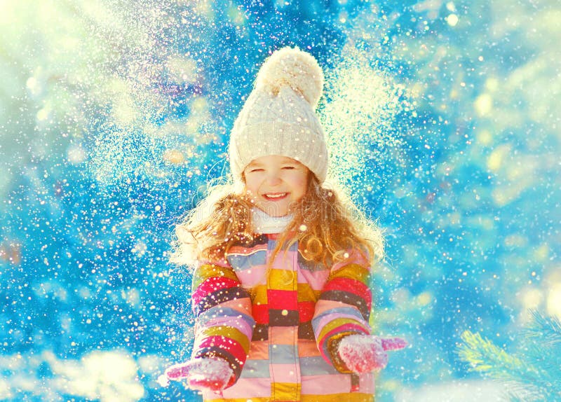 Vrolijke de winter weinig kind werpt het spelen op sneeuw stock afbeelding Vrolijke de winter weinig kind werpt het spelen op sneeuw stock afbeelding