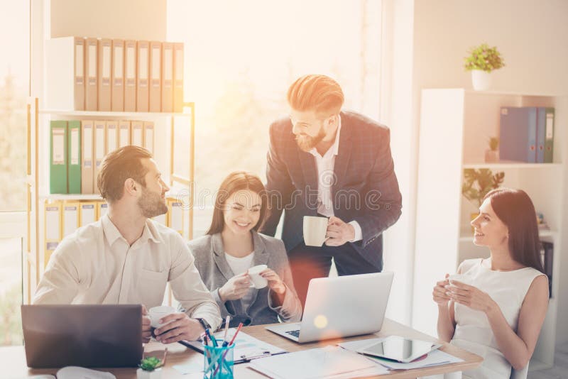 Vrolijke gelukkige collega's in slimme kleren die aardige conversat hebben stock fotografie Vrolijke gelukkige collega's in slimme kleren die aardige conversat hebben stock fotografie