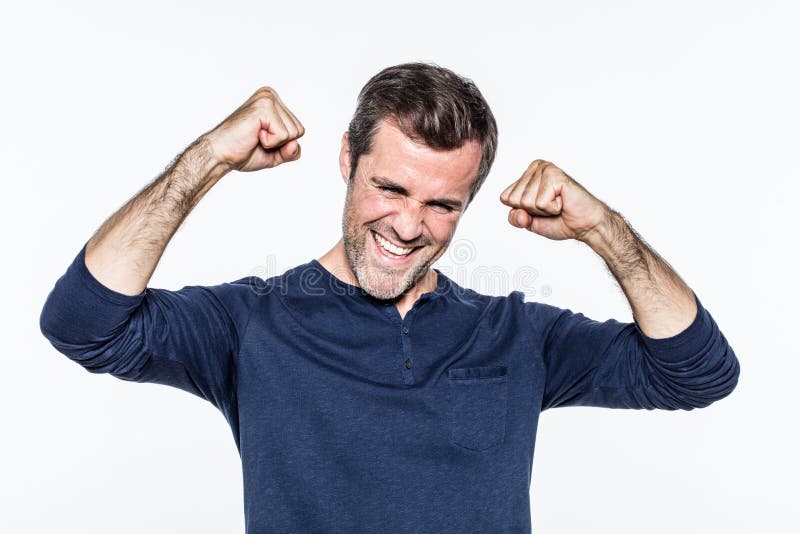 Vrolijke jonge gebaarde mens die en met omhoog vuisten glimlachen lachen royalty-vrije stock fotografie Vrolijke jonge gebaarde mens die en met omhoog vuisten glimlachen lachen royalty-vrije stock fotografie
