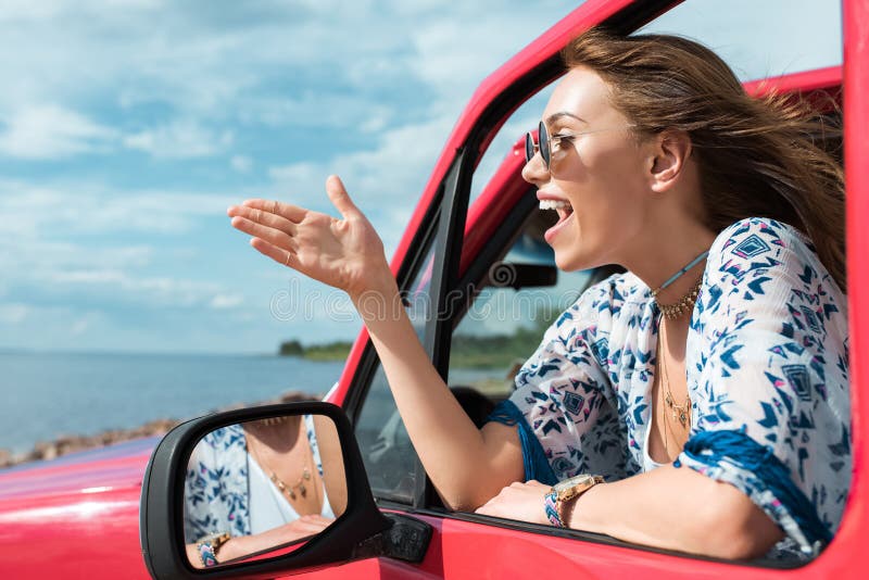 vrolijke jonge vrouw die en in auto gesturing spreken royalty-vrije stock afbeeldingen vrolijke jonge vrouw die en in auto gesturing spreken royalty-vrije stock afbeeldingen