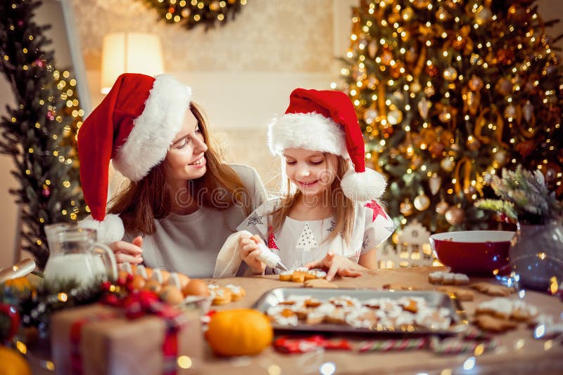 Vrolijke Kerstmis en gelukkige vakantie Moeder en dochter kokende Kerstmiskoekjes royalty-vrije stock afbeeldingen Vrolijke Kerstmis en gelukkige vakantie Moeder en dochter kokende Kerstmiskoekjes royalty-vrije stock afbeeldingen